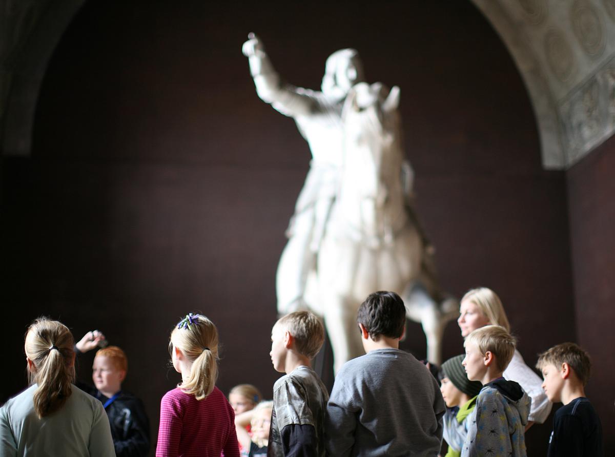 Børn i forhallen med skulptur i baggrunden