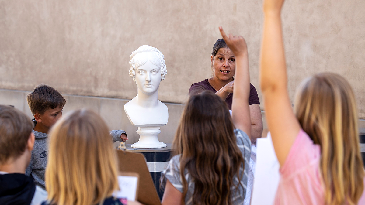 Skoleelever får undervisning, nogle med hånden i vejret