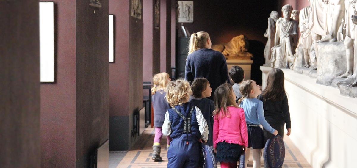 Børnehavebørn ser på skulpturer i korridoren